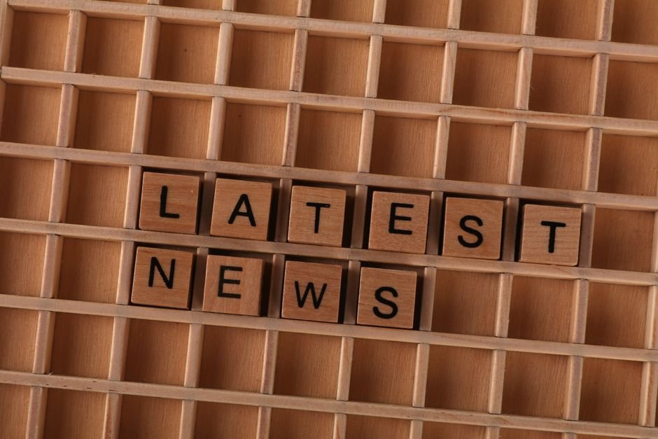 Wooden letter blocks spelling Latest News on a grid background, ideal for media themes.
